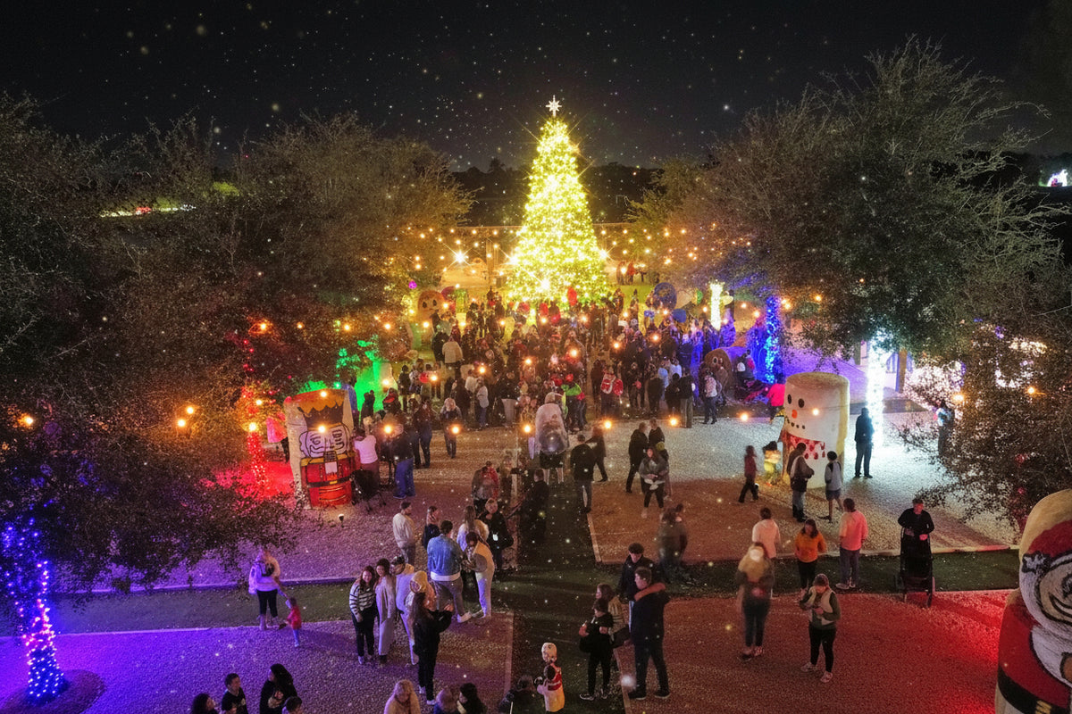A nighttime outdoor scene at The Berry Farm with a large, illuminated Christmas tree centered in a park-like plaza, surrounded by many people walking and gathering for the 7th Annual tree Lighting ceremony. Trees, string lights, and colorful holiday decorations are visible across the scene.